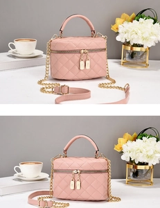 Détail du sac bandoulière rose matelassé avec chaîne dorée et fermeture à double zip