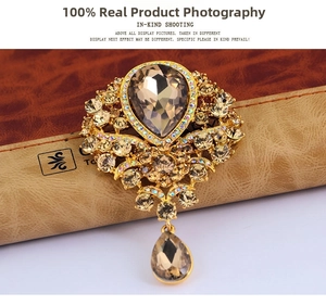 Detailed close-up of champagne teardrop glass pendant brooch with rhinestone inlay