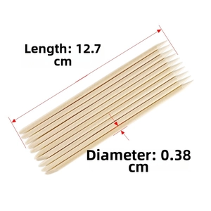 Detail view of double-ended orange wood nail sticks measuring 12.7cm by 0.38cm size