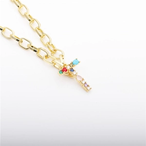 Close-up of gold plated cross pendant with vibrant multi-color zircon stones and textured link chain
