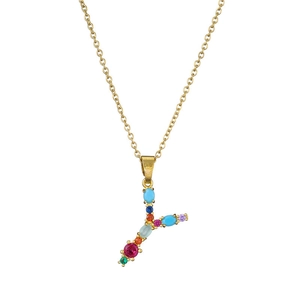 Macro detail of golden letter Y necklace pendant inlaid with colorful vibrant gemstones