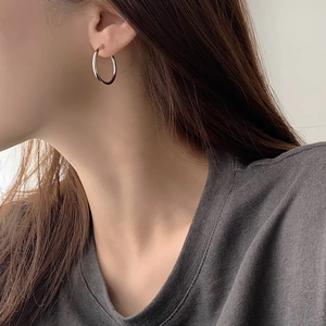 Minimalist S925 sterling silver hoop earrings with elegant curved tube design on model