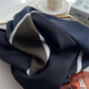 Detail view of cotton linen scarf with blue and brown geometric color block patterns