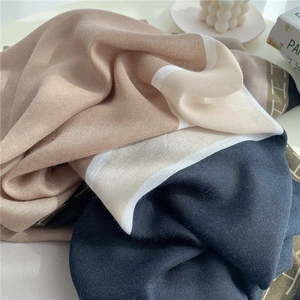 Close-up of a soft cotton-linen blend scarf with geometric H patterns and Paris book deco