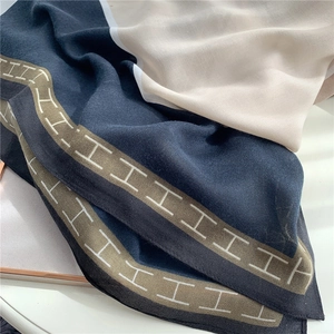 Close-up of geometric H pattern on soft navy and beige cotton linen pashmina shawl scarf