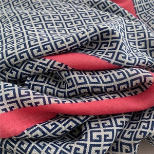 Detail of soft cotton scarf featuring blue Greek key pattern and pink color block