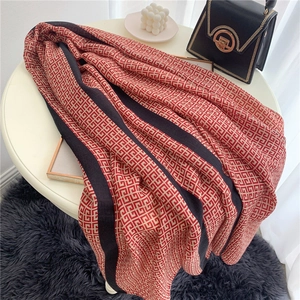 Detail of soft cotton scarf with geometric pattern and black stripes on a white table