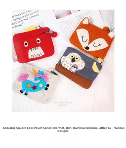 Detail of four handmade wool felt coin purses in fox and owl shapes on soft plush background