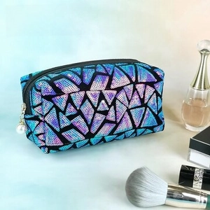 Detail of sequined coin purse with blue geometric pattern and white pearl zipper pull