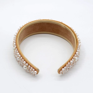 Detailed macro view of white pearls and golden beads on a baroque luxury headband
