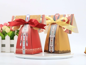 Détail de boîtes de mariage chinoises rouge et or avec ruban satiné et motifs traditionnels