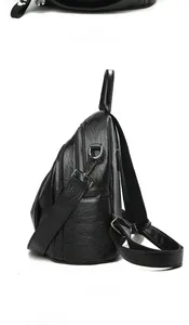Close-up of black lychee grain leather crossbody bag showing silver zippers and strap detail
