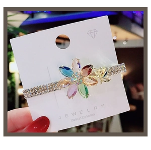 Macro detail of crystal flower hair clip with colorful marquise stones and gold alloy base