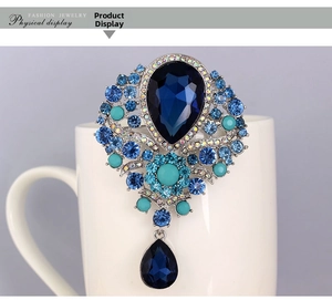 Macro shot of royal palace style brooch with blue waterdrop crystals and silver alloy