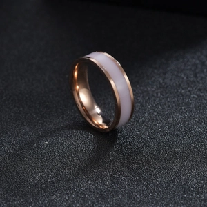 Macro detail of 6mm rose gold titanium steel ring with white enamel inlay and polished finish