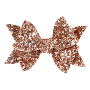 Detailed macro view of rose gold glitter bow hair clip with sparkling sequin texture