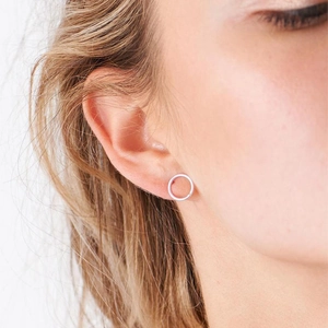Gros plan de boucles d'oreilles rondes et creuses en argent portées par un mannequin