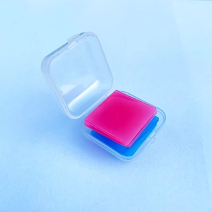 Macro view of blue and pink square wax pieces organized in a clear plastic storage box
