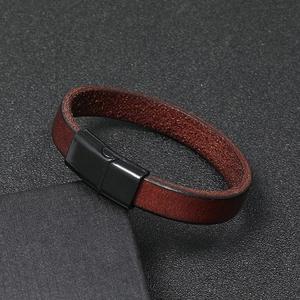 Detailed view of brown leather bracelet with black magnetic clasp on textured gift box