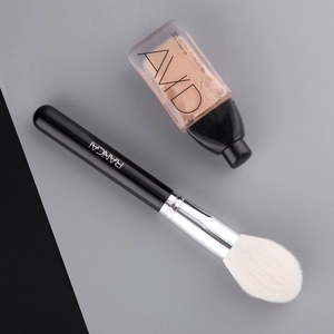 Flame shaped highlighter brush with soft white bristles and sleek black handle