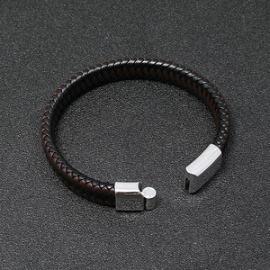 Dettaglio del bracciale in pelle intrecciata nero e marrone con chiusura magnetica in acciaio