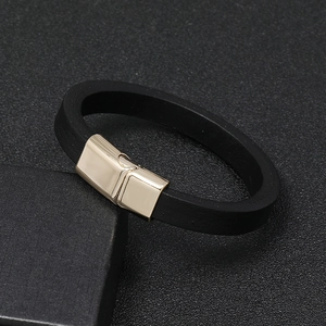 Close-up of black leather bracelet featuring a polished gold magnetic alloy clasp