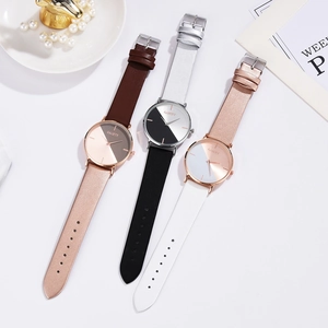 Detailed view of three minimalist quartz watches with bi-color dials and leather straps