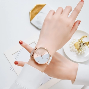 Close-up of GAIETY two-tone watch with beige leather strap on a model's wrist