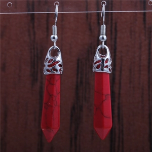 Detail of red stone hexagonal prism earrings with silver openwork metal floral caps