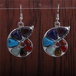 Detailed macro view of spiral silver earrings with colorful inlaid natural gemstones