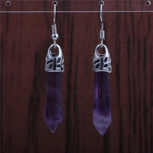 Macro shot of purple crystal hexagonal earrings with silver-toned metal hooks and settings