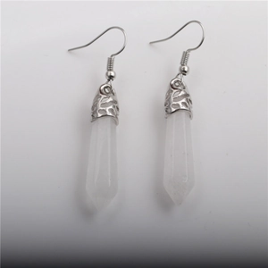 Close-up of white hexagonal crystal pillar earrings with silver fishhook wires and metal caps
