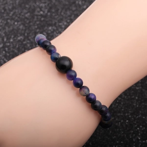 Detail of beaded bracelet with blue and purple tiger eye stones on a male wrist model