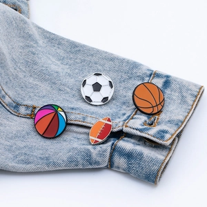 Lot de pins émaillés sport avec ballon de foot et basket sur une veste en jean bleue