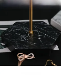 Detail der sechseckigen schwarzen Marmorbasis für Schmuckständer mit Goldstab