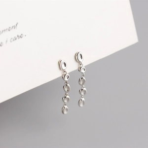 Macro detail of S925 sterling silver long tassel earrings with irregular pebble links