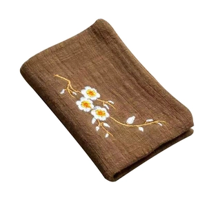 Deep brown cotton linen tea towel with elegant white floral embroidery on white background