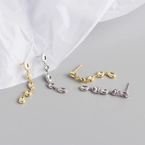 Detail of silver and gold fringe earrings with irregular metallic polished segments