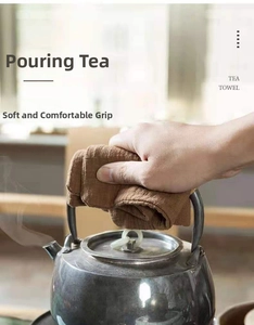 Brown cotton linen tea towel used as a heat-resistant pot holder for a metal teapot