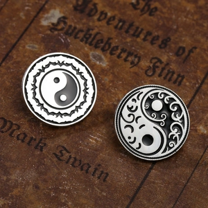 Detail von Vintage Tai-Chi Yin Yang Broschen aus Metall auf klassischem Buchhintergrund