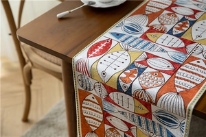 Detailed texture of chenille table runner featuring colorful geometric fish patterns