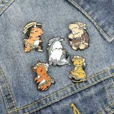 Detail of five cute enamel animal brooches with inspirational quotes on denim fabric