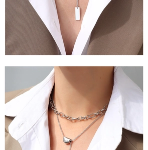 Close-up of double layer silver titanium steel necklace with square pendant on model