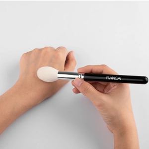 Detail of angled contour brush with dense white bristles and sleek black handle