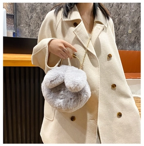 Detailed view of plush rabbit ear bag featuring a gold ring handle and metal chain strap
