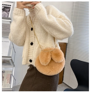 Detail of warm brown plush crossbody bag with cute rabbit ears and gold chain strap
