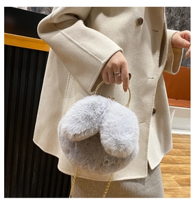 Detail of plush bunny ear handbag with gold metal handle and luxury faux fur texture