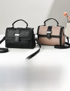 Detail of woven texture handbag with metal buckle closure and top handle design