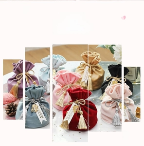 Close-up of velvet drawstring gift bags with silk tassels and festive gift tags