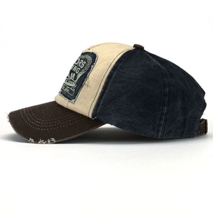 Detail of vintage baseball cap featuring distressed brim and tricolor patchwork design
